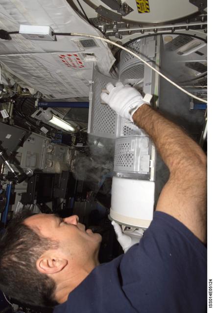 NASA image: Lopez-Alegria with Passive Observatories for Experimental Microbial Systems in Micro-G (POEMS) sample container