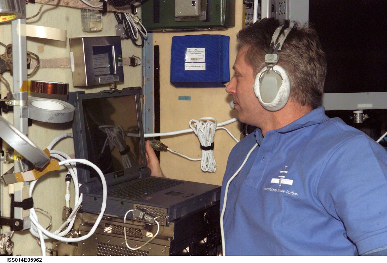 ISS014-E-05962 (October 2006) --- European Space Agency (ESA) astronaut Thomas Reiter, Expedition 14 flight engineer, wears a communication system headset while using a computer in the Zvezda Service Module of the International Space Station.