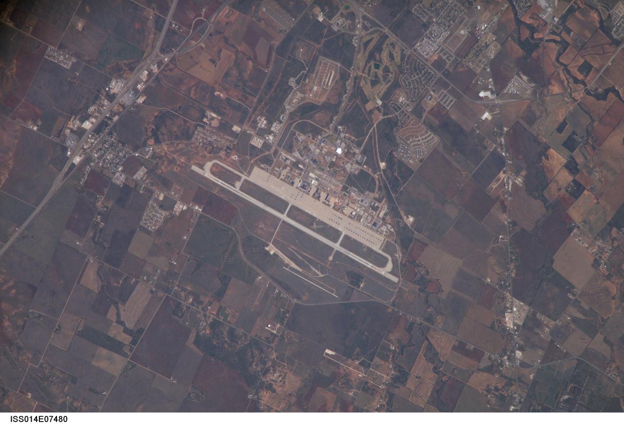 ISS014-E-07480 (11 Nov. 2006) --- Dyess Air Force Base is featured in this image photographed by an Expedition 14 crewmember on the International Space Station. Dyess Air Force Base, located near the central Texas city of Abilene, is the home of the 7th Bomb Wing and 317th Airlift Groups of the United States Air Force. The Base also conducts all initial Air Force combat crew training for the B-1B Lancer aircraft. The main runway is approximately 5 kilometers in length to accommodate the large bombers and cargo aircraft at the base -- many of which are parked in parallel rows on the base tarmac. Lieutenant Colonel William E. Dyess, for whom the base is named, was a highly decorated pilot, squadron commander, and prisoner of war during World War II. The nearby town of Tye, Texas was established by the Texas and Pacific Railway in 1881, and expanded considerably following reactivation of a former air field as Dyess Air Force Base in 1956. Airfields and airports are useful sites for astronauts to hone their long camera lens photographic technique to acquire high resolution images. The sharp contrast between highly reflective linear features, such as runways, with darker agricultural fields and undisturbed land allows fine focusing of the cameras. This on-the-job training is key for obtaining high resolution imagery of Earth, as well as acquiring inspection photographs of space shuttle thermal protection tiles during continuing missions to the International Space Station.