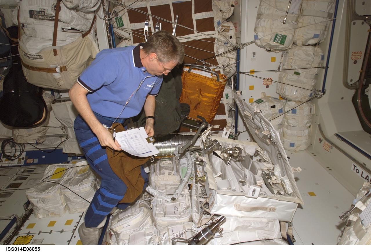 ISS014-E-08055 (16 Nov. 2006) --- European Space Agency (ESA) astronaut Thomas Reiter, Expedition 14 flight engineer, takes inventory of hardware during an Information Management System (IMS) update in the Unity node of the International Space Station.