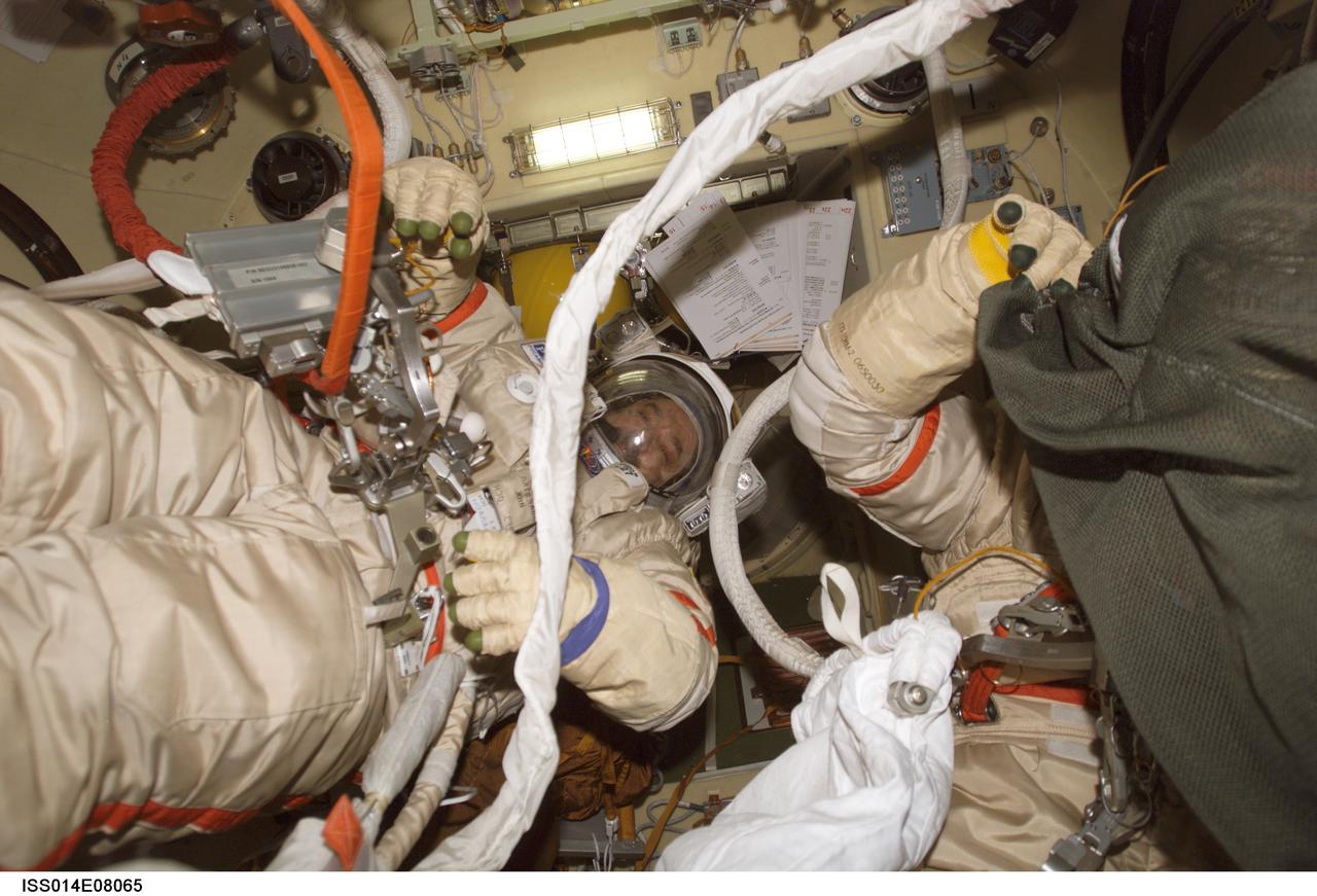 ISS014-E-08065 (17 Nov. 2006) --- Cosmonaut Mikhail Tyurin (left), Expedition 14 flight engineer representing Russia's Federal Space Agency, and astronaut Michael E. Lopez-Alegria (partially obscured), commander, participate in an Russian Orlan spacesuit translation exercise in the Pirs Docking Compartment of the International Space Station as they prepare for their spacewalk scheduled for Nov. 22.