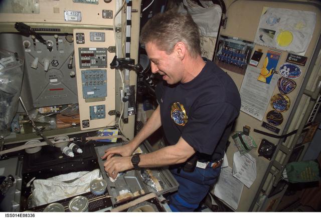 NASA image: Reiter with food cans in galley area of Zvezda Service module