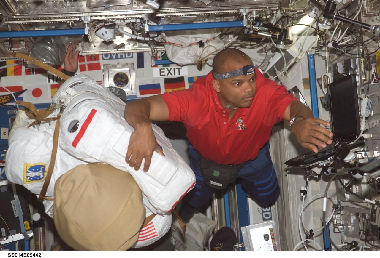 ISS014-E-09442 (12 Dec. 2006) --- Astronaut Robert L. Curbeam, Jr., STS-116 mission specialist, floats with his Extravehicular Mobility Unit (EMU) spacesuit in the Destiny laboratory of the International Space Station as he prepares for the mission's first scheduled session of extravehicular activity (EVA).