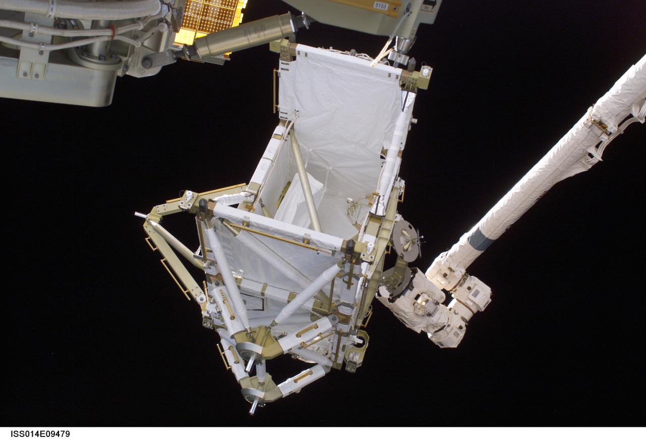 ISS014-E-09479 (12 Dec. 2006) --- The International Space Station's new P5 truss section awaits installation following the hand-off from Space Shuttle Discovery's Remote Manipulator System (RMS) robotic arm. The truss section was handed to the station's Canadarm2 and remained suspended over Discovery's port wing overnight, awaiting installation in the first of three planned spacewalks on Dec. 12.