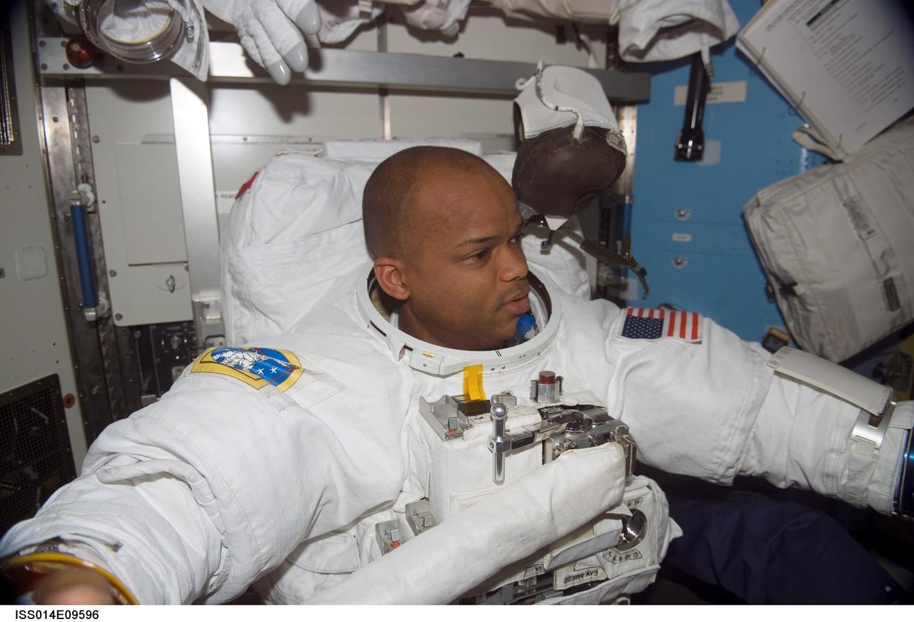 ISS014-E-09596 (12 Dec. 2006) --- Attired in his extravehicular mobility unit (EMU) spacesuit, astronaut Robert L. Curbeam, Jr., STS-116 mission specialist, prepares for the mission's first session of extravehicular activity (EVA) in the Quest Airlock of the International Space Station while Space Shuttle Discovery was docked with the station.