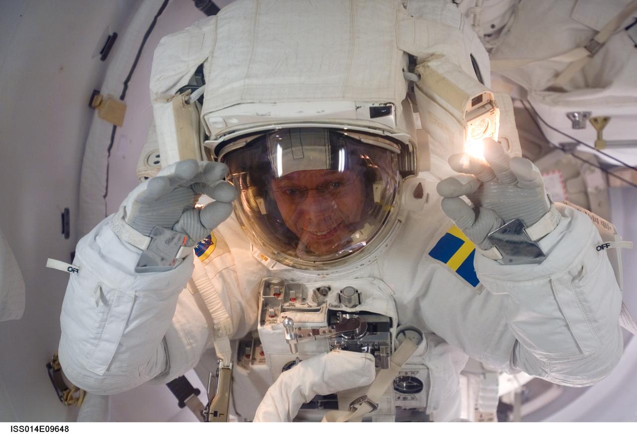 ISS014-E-09648 (12 Dec. 2006) --- As the mission's first spacewalk draws to a close, European Space Agency (ESA) astronaut Christer Fuglesang, STS-116 mission specialist, moves through the Quest Airlock as he returns to the International Space Station.