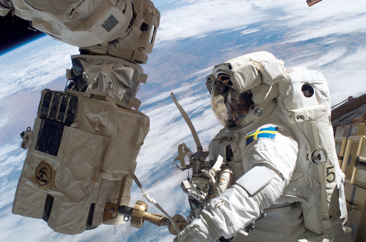 ISS014-E-09778 (14 Dec. 2006) --- European Space Agency (ESA) astronaut Christer Fuglesang, STS-116 mission specialist, participates in the mission's second of three planned sessions of extravehicular activity (EVA) as construction resumes on the International Space Station. Astronaut Robert L. Curbeam, Jr. (out of frame), mission specialist, also participated in the spacewalk. The station's Canadarm2 end effector is at left.