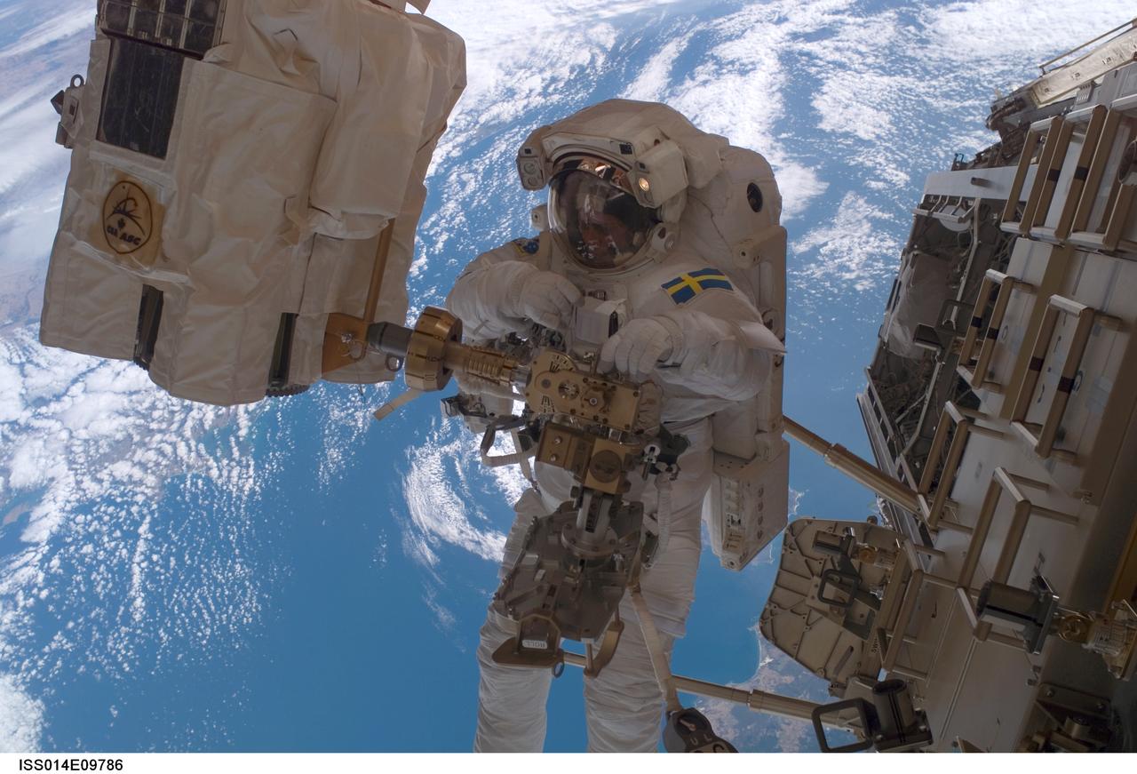 ISS014-E-09786 (14 Dec. 2006) --- European Space Agency (ESA) astronaut Christer Fuglesang, STS-116 mission specialist, participates in the mission's second of three planned sessions of extravehicular activity (EVA) as construction resumes on the International Space Station. Astronaut Robert L. Curbeam, Jr. (out of frame), mission specialist, also participated in the spacewalk. The station's Canadarm2 end effector is at left.