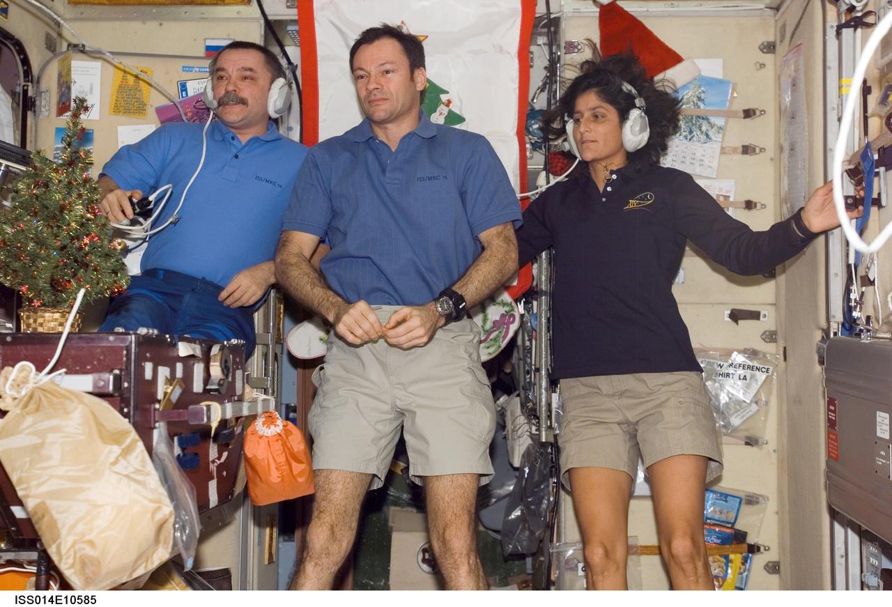 ISS014-E-10585 (28 Dec. 2006) --- Cosmonaut Mikhail Tyurin (left), Expedition 14 flight engineer representing Russia's Federal Space Agency; astronaut Michael E. Lopez-Alegria, commander and NASA space station science officer; and astronaut Sunita L. Williams, flight engineer, conduct a New Year press conference for journalists in the Zvezda Service Module of the International Space Station.