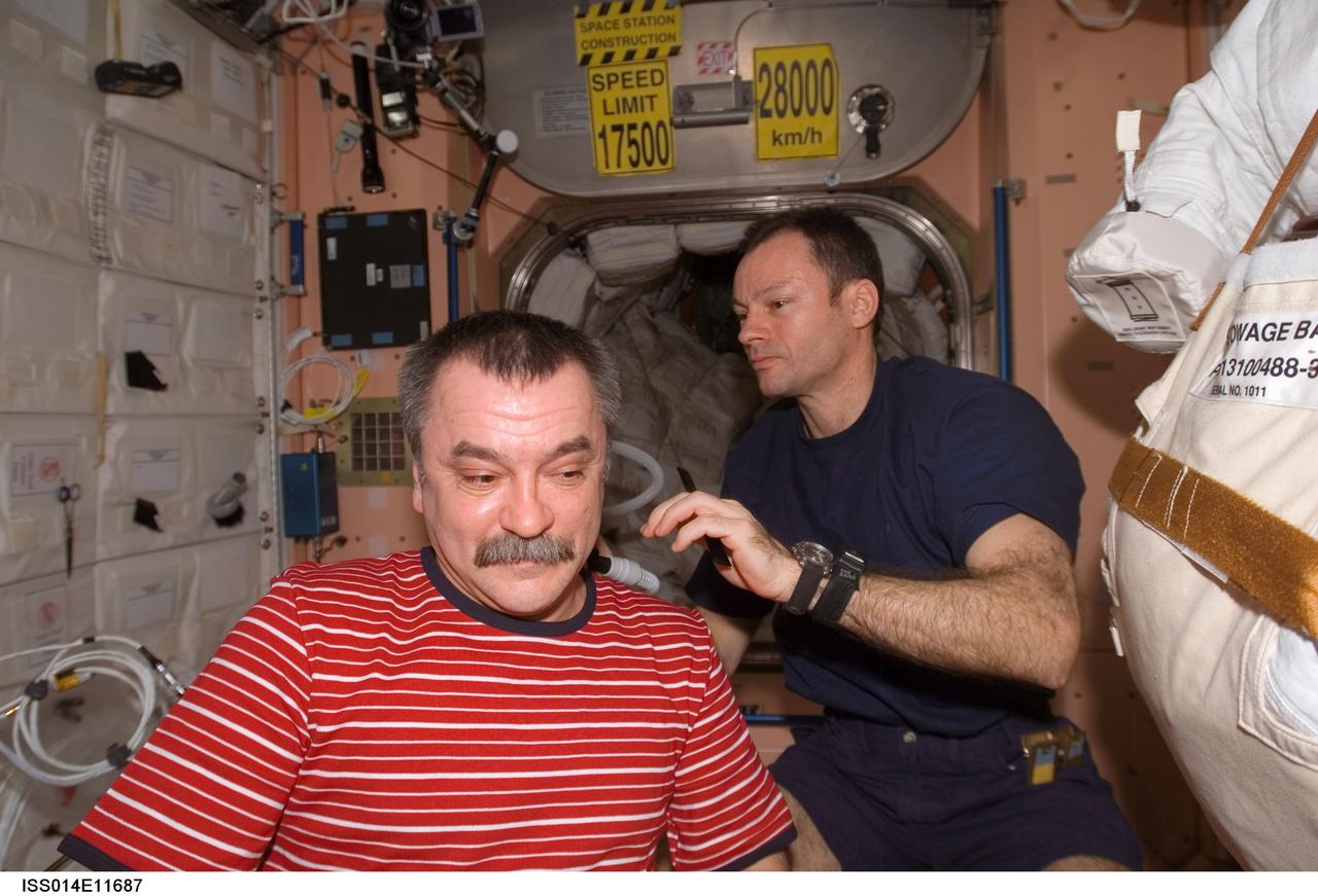 ISS014-E-11687 (11 Jan. 2007) --- Astronaut Michael E. Lopez-Alegria, Expedition 14 commander and NASA space station science officer, trims cosmonaut Mikhail Tyurin's hair in the Unity node of the International Space Station. Lopez-Alegria used hair clippers fashioned with a vacuum device to garner freshly cut hair. Tyurin, flight engineer, represents Russia's Federal Space Agency.