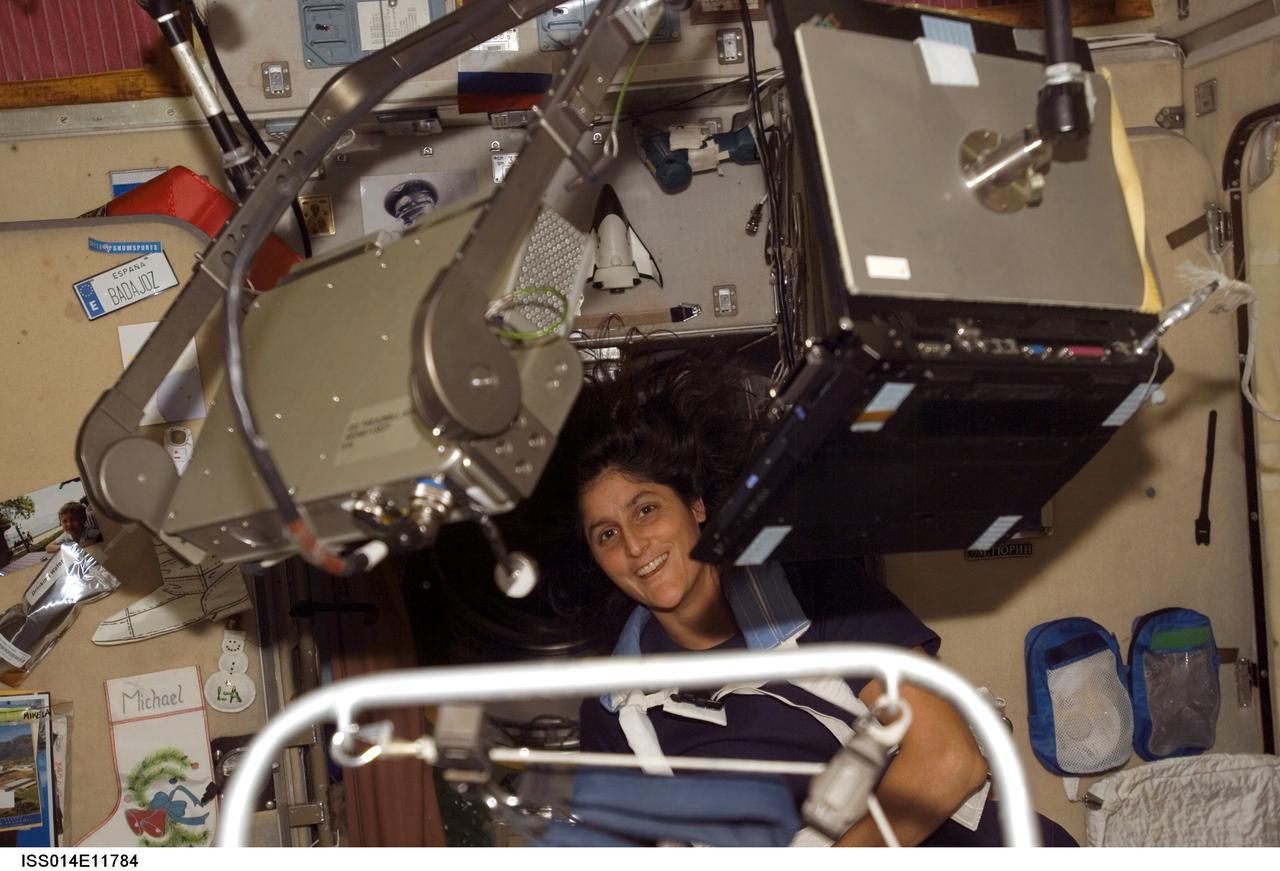 ISS014-E-11784 (13 Jan. 2007) --- Surrounded by hardware, astronaut Sunita L. Williams, Expedition 14 flight engineer, equipped with a bungee harness, exercises on the Treadmill Vibration Isolation System (TVIS) (out of frame) in the Zvezda Service Module of the International Space Station.