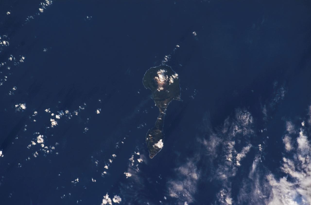 ISS014-E-11872 (11 Jan. 2007) --- Pagan Island, Northern Mariana Islands, is featured in this image photographed by an Expedition 14 crewmember on the International Space Station. According to scientists, the Mariana Islands are part a volcanic island arc -- surface volcanoes formed from magma generation as one tectonic plate is overridden (or subducted) beneath another. In the case of the Mariana Islands, the Pacific Plate is being subducted beneath the Philippine Plate along the famously deep Mariana Trench (more than 11 kilometers below sea level). Pagan Island (right) is comprised of two stratovolcanoes (tall, typically cone-shaped structures formed by layers of dense crystallized lava and less-dense ash and pumice) connected by a narrow isthmus of land. Mount Pagan, the larger of the two volcanoes, forms the northeastern portion of the island and has been the most active historically. The most recent major eruption took place in 1981, but since then numerous steam- and ash-producing events have been observed at the volcano -- the latest reported one occurring between Dec. 5-8, 2006. This image records volcanic activity on Jan. 11, 2007 that produced a thin plume (most probably steam, say NASA scientists, possibly with minor ash content) that extended westwards away from Mount Pagan. The island is sparsely populated, and monitored for volcanic activity by the United States Geological Survey and the Commonwealth of the Mariana Islands.