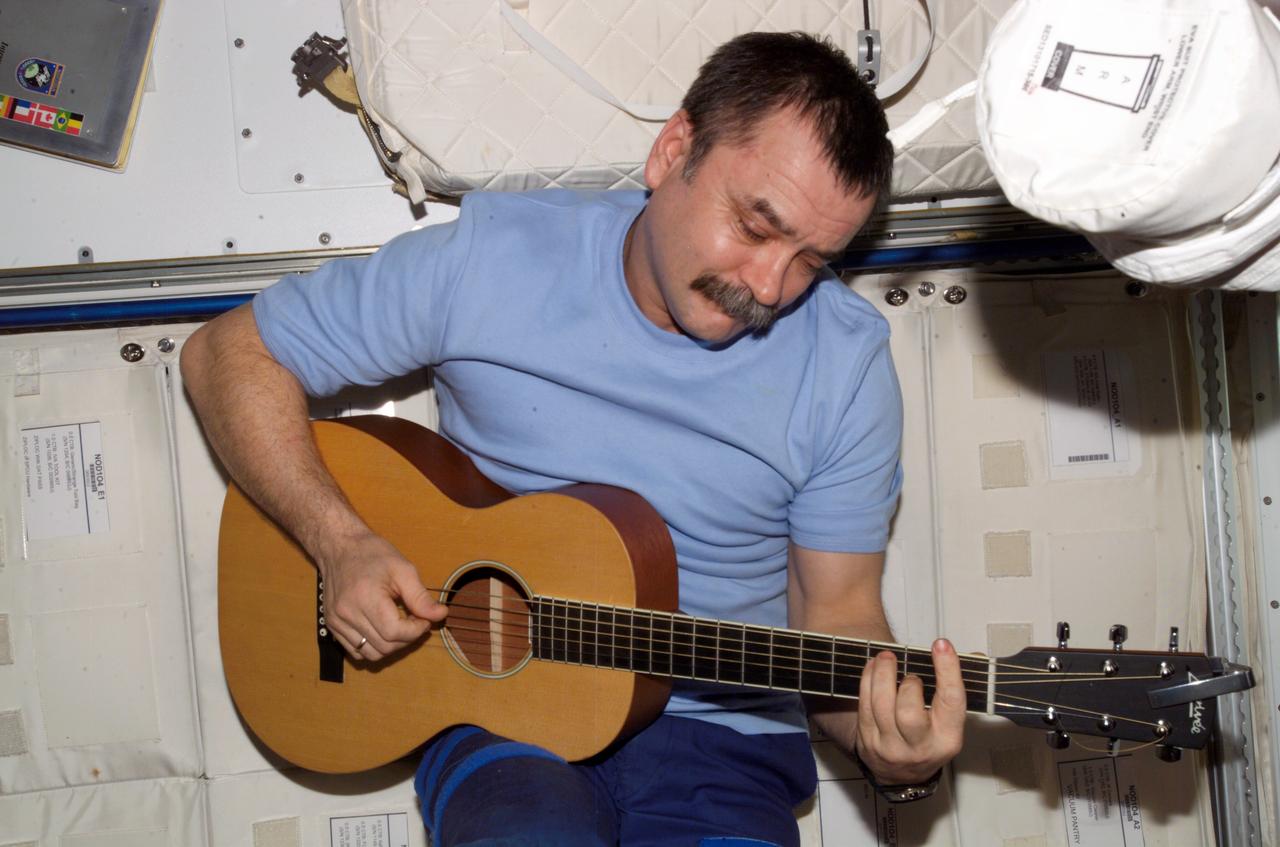 ISS014-E-12466 (19 Jan. 2007) --- Cosmonaut Mikhail Tyurin, Expedition 14 flight engineer representing Russia's Federal Space Agency, plays a guitar in the Unity node of the International Space Station.