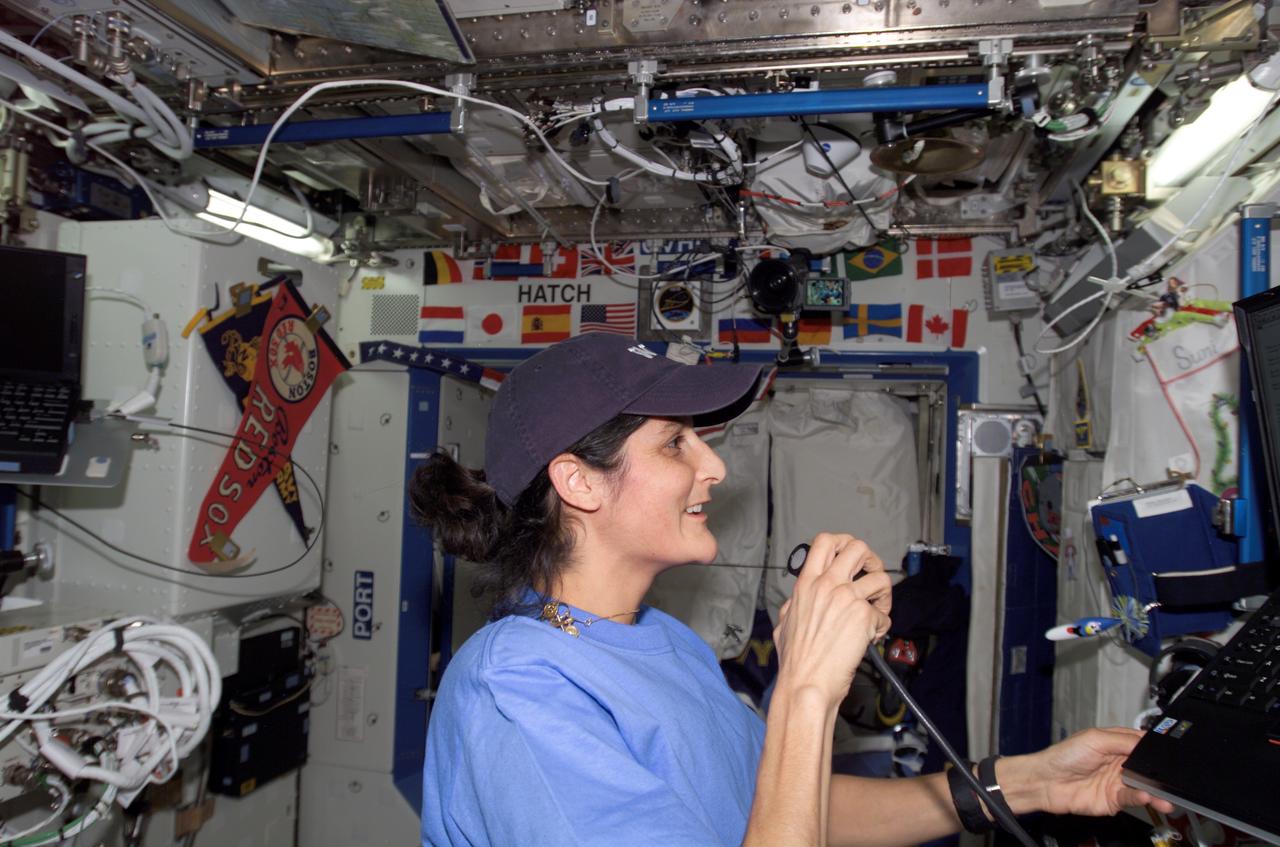 ISS014-E-12995 (26 Jan. 2007) --- Astronaut Sunita L. Williams, Expedition 14 flight engineer, uses a communication system in the Destiny laboratory of the International Space Station.