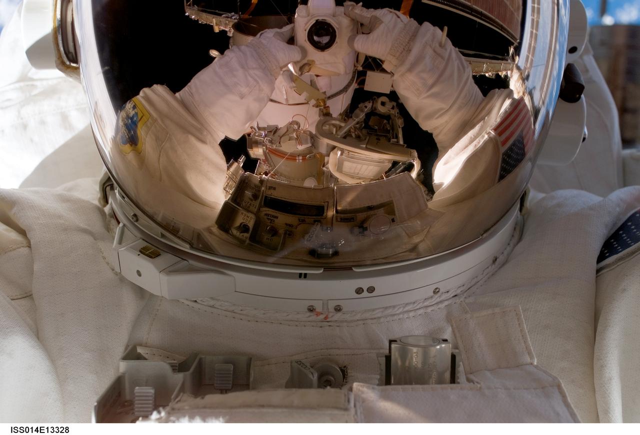 ISS014-E-13328 (4 Feb. 2007) --- Astronaut Sunita L. Williams, Expedition 14 flight engineer, uses a digital still camera to expose a photo of her helmet visor during today's session of extravehicular activity (EVA) as construction continues on the International Space Station. During the spacewalk, Williams and Michael E. Lopez-Alegria (out of frame), commander and NASA space station science officer, reconfigured the second of two cooling loops for the Destiny laboratory module, secured the aft radiator of the P6 truss after retraction and prepared the obsolete Early Ammonia Servicer (EAS) for removal this summer.