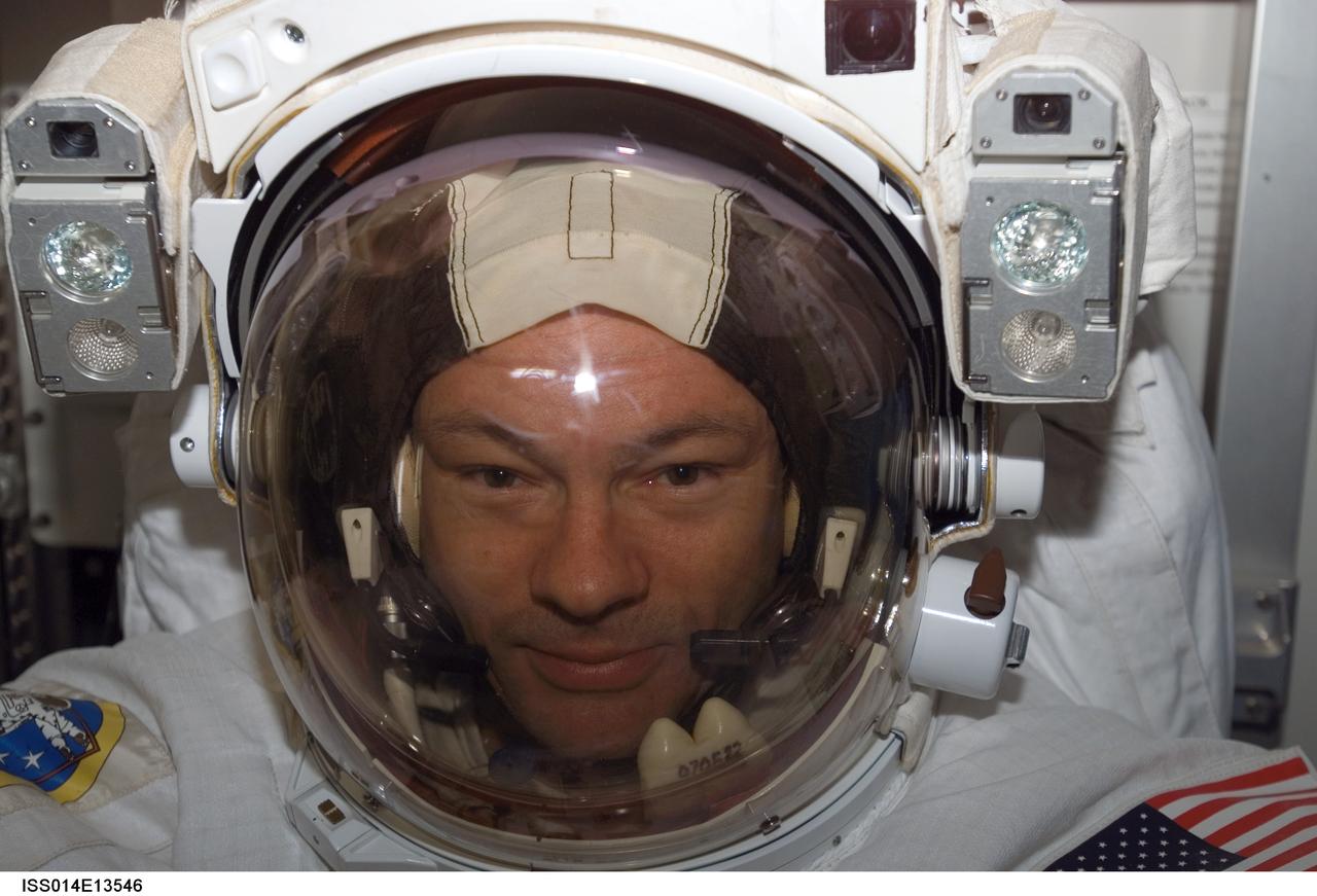 ISS014-E-13546 (8 Feb. 2007) --- Astronaut Michael E. Lopez-Alegria, Expedition 14 commander and NASA space station science officer, attired in his Extravehicular Mobility Unit (EMU) spacesuit, awaits the start of the third session of extravehicular activity (EVA) in nine days in the Quest Airlock of the International Space Station.