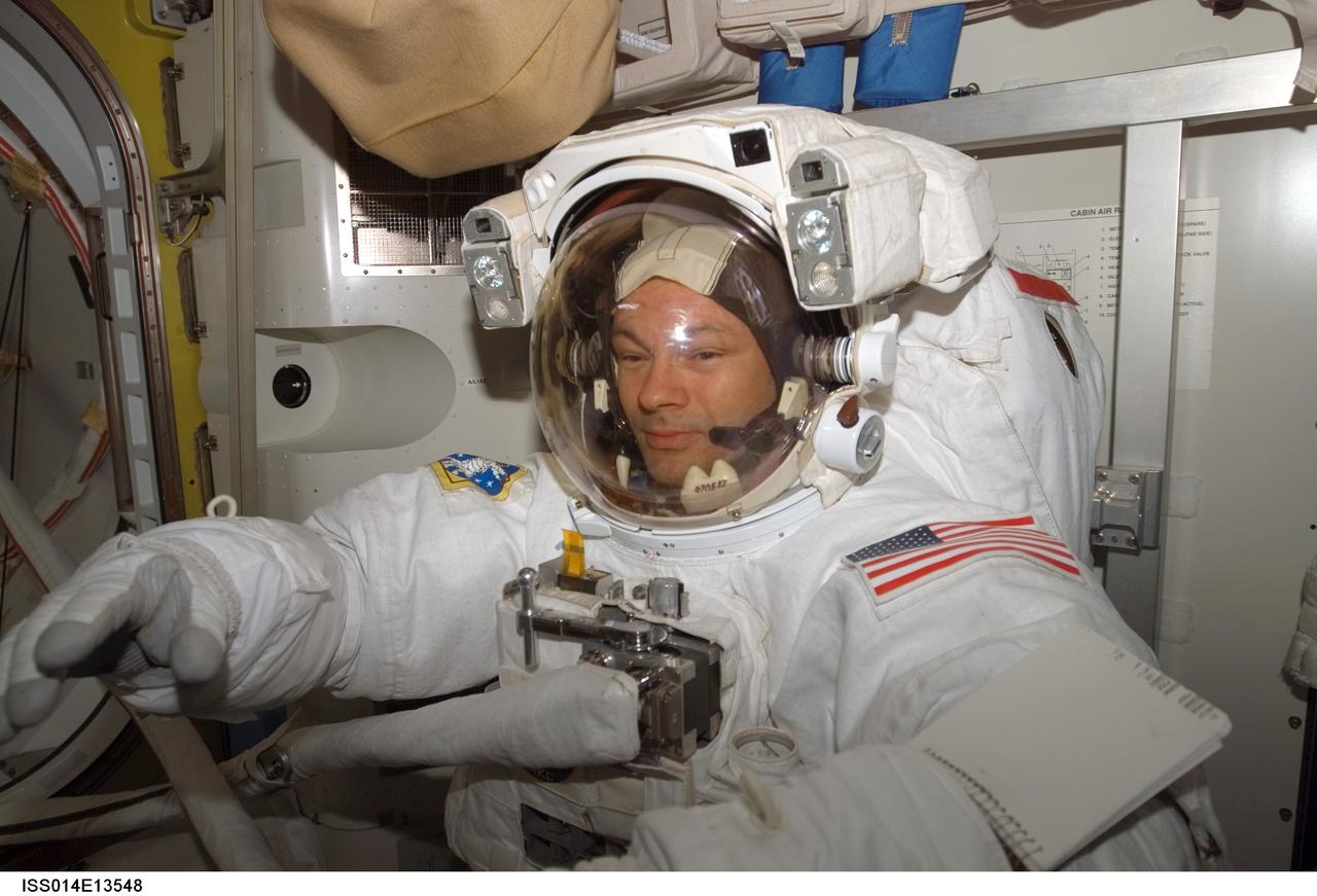 ISS014-E-13548 (8 Feb. 2007) --- Astronaut Michael E. Lopez-Alegria, Expedition 14 commander and NASA space station science officer, attired in his Extravehicular Mobility Unit (EMU) spacesuit, awaits the start of the third session of extravehicular activity (EVA) in nine days in the Quest Airlock of the International Space Station.