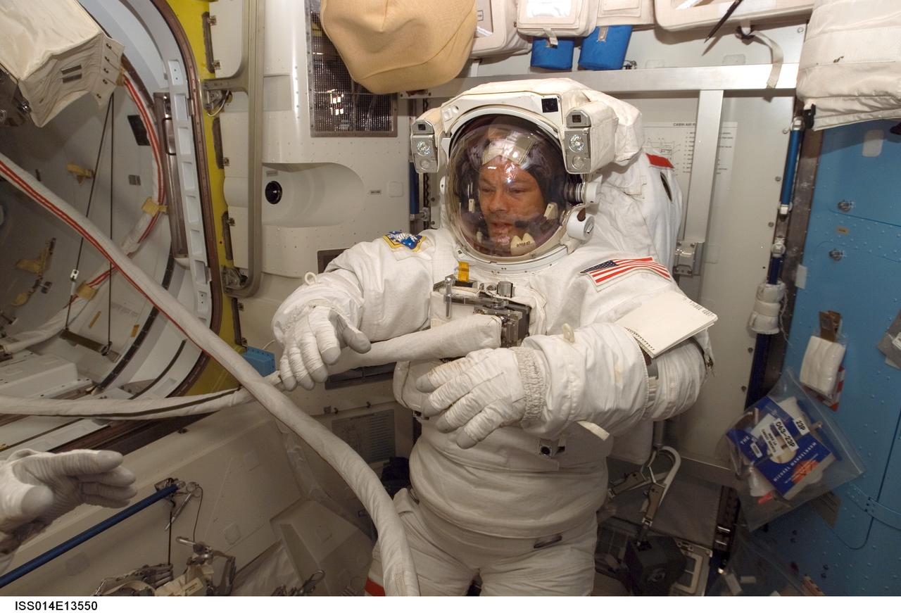 ISS014-E-13550 (8 Feb. 2007) --- Astronaut Michael E. Lopez-Alegria, Expedition 14 commander and NASA space station science officer, attired in his Extravehicular Mobility Unit (EMU) spacesuit, awaits the start of the third session of extravehicular activity (EVA) in nine days in the Quest Airlock of the International Space Station.