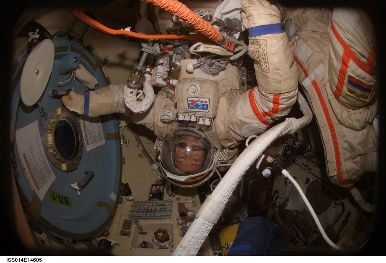 ISS014-E-14605 (20 Feb. 2007) --- Astronaut Michael E. Lopez-Alegria, Expedition 14 commander and NASA space station science officer, performs a Russian Orlan spacesuit fit check in the Pirs Docking Compartment of the International Space Station. The Expedition 14 crewmembers are two days away from their final scheduled spacewalk.