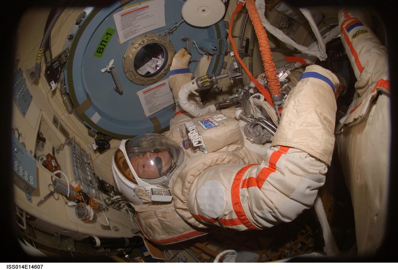 ISS014-E-14607 (20 Feb. 2007) --- Astronaut Michael E. Lopez-Alegria, Expedition 14 commander and NASA space station science officer, performs a Russian Orlan spacesuit fit check in the Pirs Docking Compartment of the International Space Station. The Expedition 14 crewmembers are two days away from their final scheduled spacewalk.