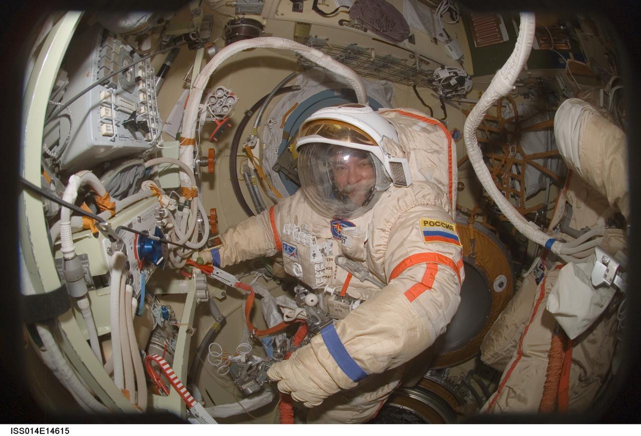 ISS014-E-14615 (20 Feb. 2007) --- Cosmonaut Mikhail Tyurin, Expedition 14 flight engineer representing Russia's Federal Space Agency, performs a Russian Orlan spacesuit fit check in the Pirs Docking Compartment of the International Space Station. The Expedition 14 crewmembers are two days away from their final scheduled spacewalk.