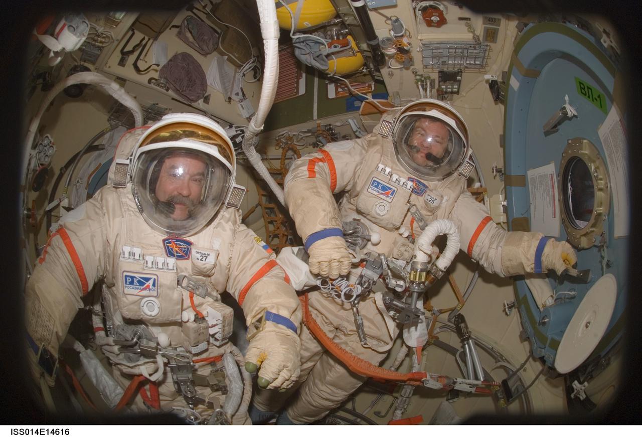 ISS014-E-14616 (20 Feb. 2007) --- Astronaut Michael E. Lopez-Alegria (right), Expedition 14 commander and NASA space station science officer; and cosmonaut Mikhail Tyurin, flight engineer representing Russia's Federal Space Agency, perform a Russian Orlan spacesuit fit check in the Pirs Docking Compartment of the International Space Station. The Expedition 14 crewmembers are two days away from their final scheduled spacewalk.