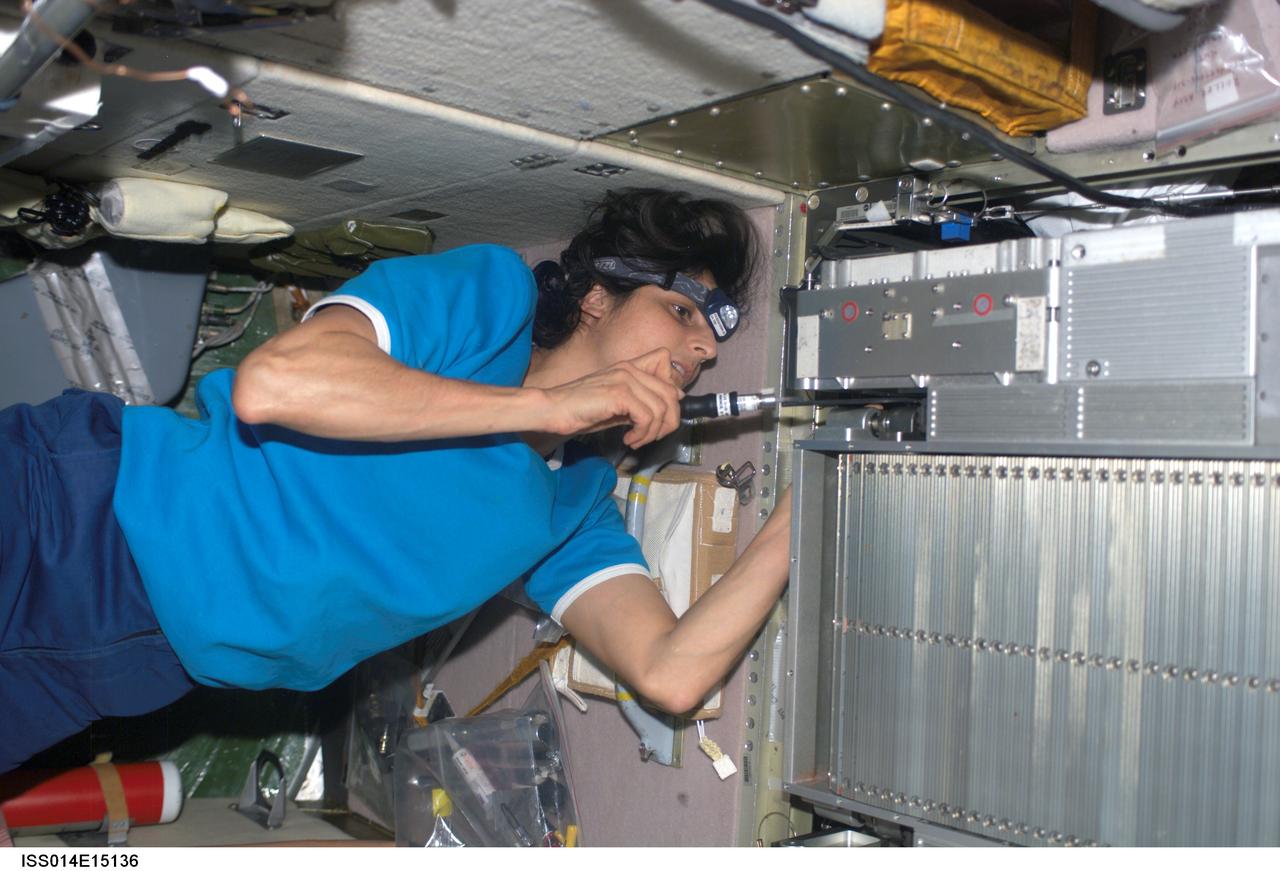ISS014-E-15136 (26 Feb. 2007) --- Astronaut Sunita L. Williams, Expedition 14 flight engineer, performs maintenance work on the Treadmill Vibration Isolation System (TVIS) during routine in-flight maintenance (IFM) in the Zvezda Service Module of the International Space Station.