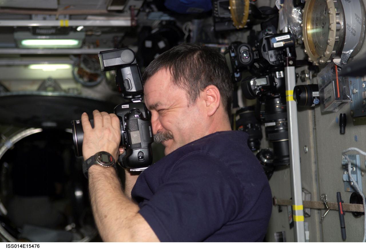 ISS014-E-15476 (28 Feb. 2007) --- Cosmonaut Mikhail Tyurin, Expedition 14 flight engineer representing Russia's Federal Space Agency, uses a digital still camera in the Zvezda Service Module of the International Space Station.