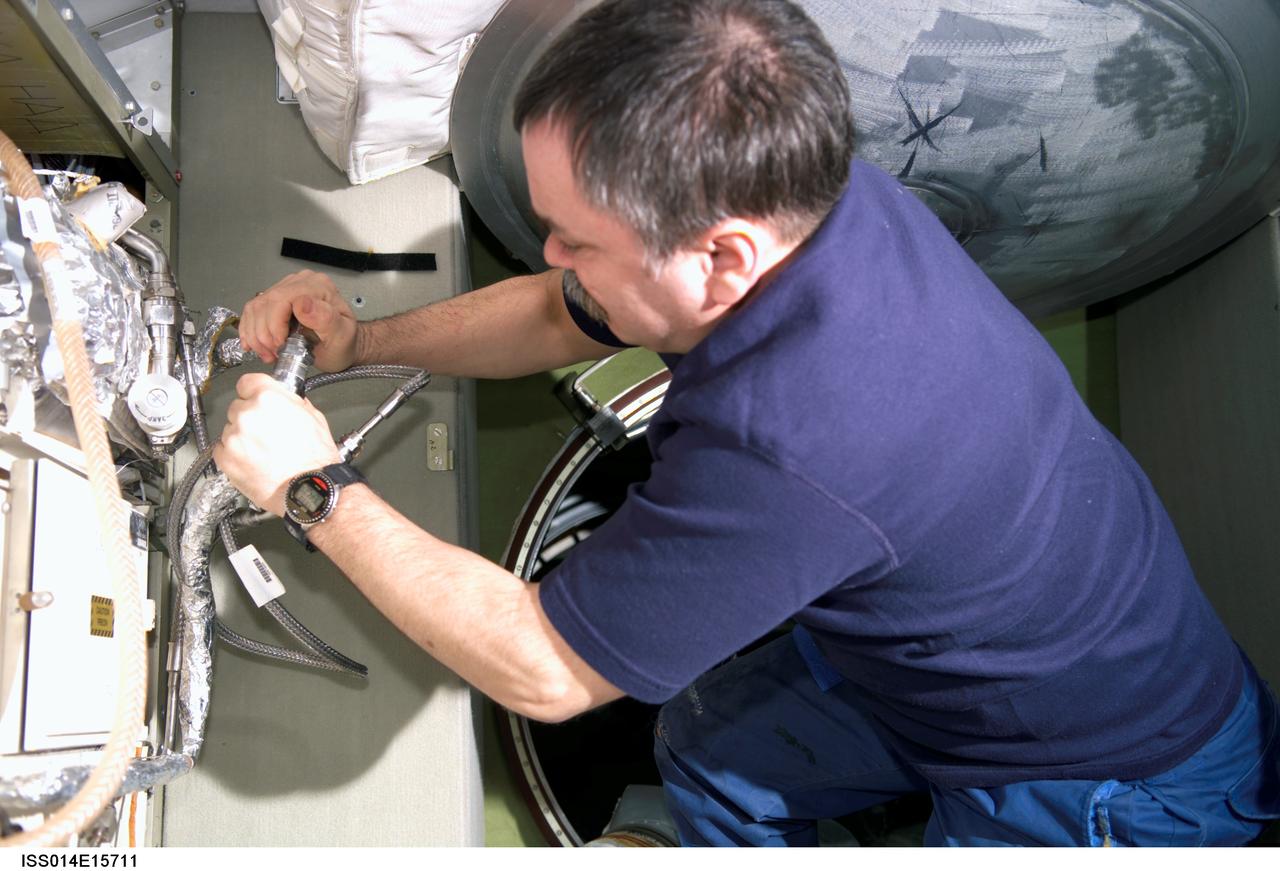 ISS014-E-15711 (1 March 2007) --- Cosmonaut Mikhail Tyurin, Expedition 14 flight engineer representing Russia's Federal Space Agency, disconnects a SKV1 heat exchanger unit during in-flight maintenance (IFM) in the Zvezda Service Module of the International Space Station.