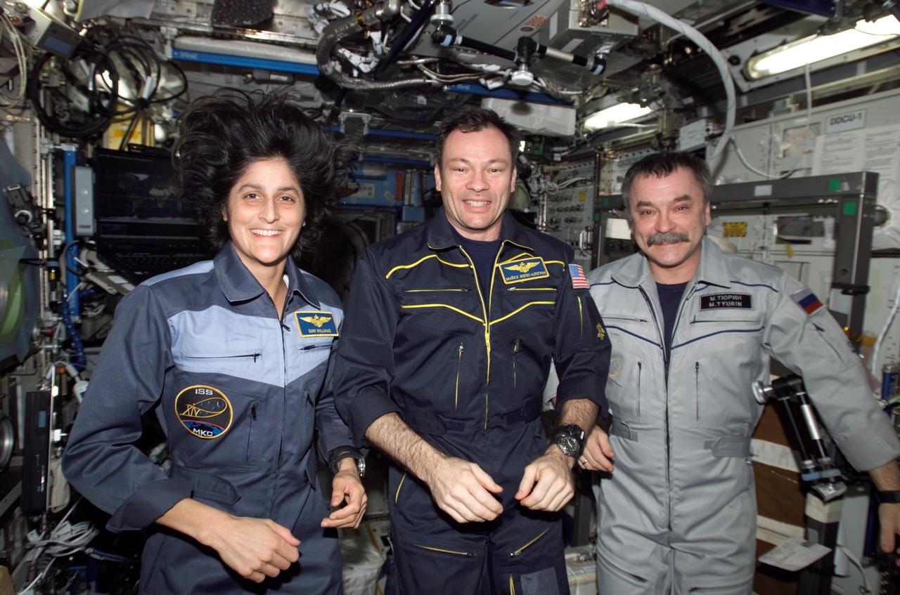 ISS014-E-16250 (8 March 2007) --- Astronauts Michael E. Lopez-Alegria (center), Expedition 14 commander and NASA space station science officer; Sunita L. Williams, flight engineer; and cosmonaut Mikhail Tyurin, flight engineer representing Russia's Federal Space Agency, pose for a crew portrait in the Destiny laboratory of the International Space Station.