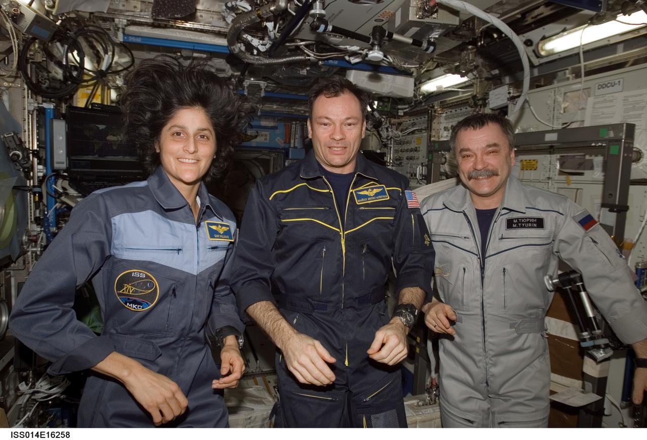 ISS014-E-16258 (8 March 2007) --- Astronauts Michael E. Lopez-Alegria (center), Expedition 14 commander and NASA space station science officer; Sunita L. Williams, flight engineer; and cosmonaut Mikhail Tyurin, flight engineer representing Russia's Federal Space Agency, pose for a crew portrait in the Destiny laboratory of the International Space Station.