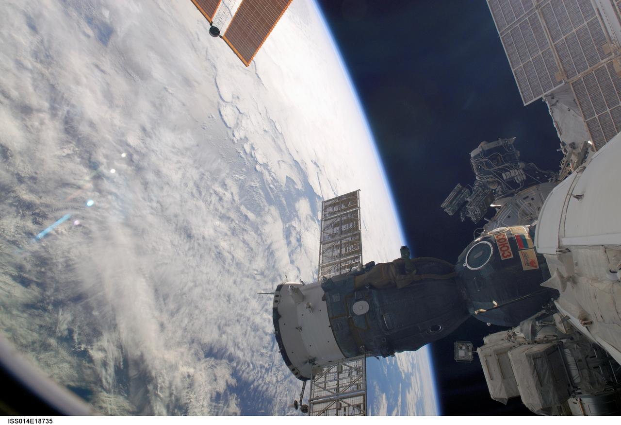 ISS014-E-18735 (29 March 2007) --- Backdropped by the blackness of space and cloud-covered Earth, the Soyuz 13 (TMA-9) spacecraft docked to the International Space Station is featured in this image photographed by an Expedition 14 crewmember prior to the relocation of the Soyuz from the Zarya Module nadir port to the Zvezda Service Module aft port.