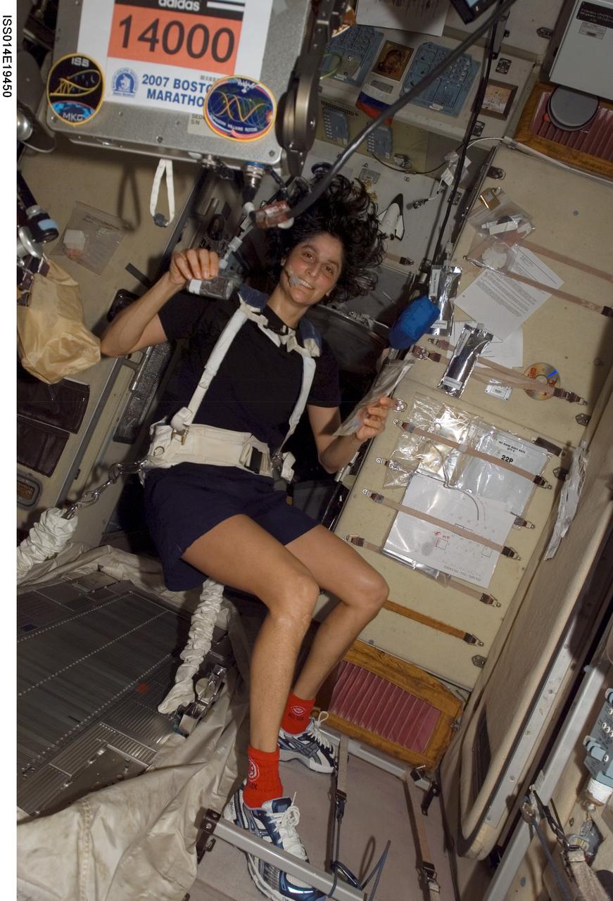 ISS014-E-19450 (16 April 2007) --- Astronaut Sunita L. Williams, Expedition 14 flight engineer, circled Earth almost three times as she participated in the Boston Marathon from space. She is seen here with her feet off the station treadmill on which she ultimately ran about six miles per hour while flying more than five miles each second. The treadmill is called TVIS, for Treadmill Vibration Isolation System, by the crewmembers and their ground support team.  Williams' official completion time was four hours, 23 minutes and 10 seconds as she completed the race at 2:24 p.m. (EDT).
