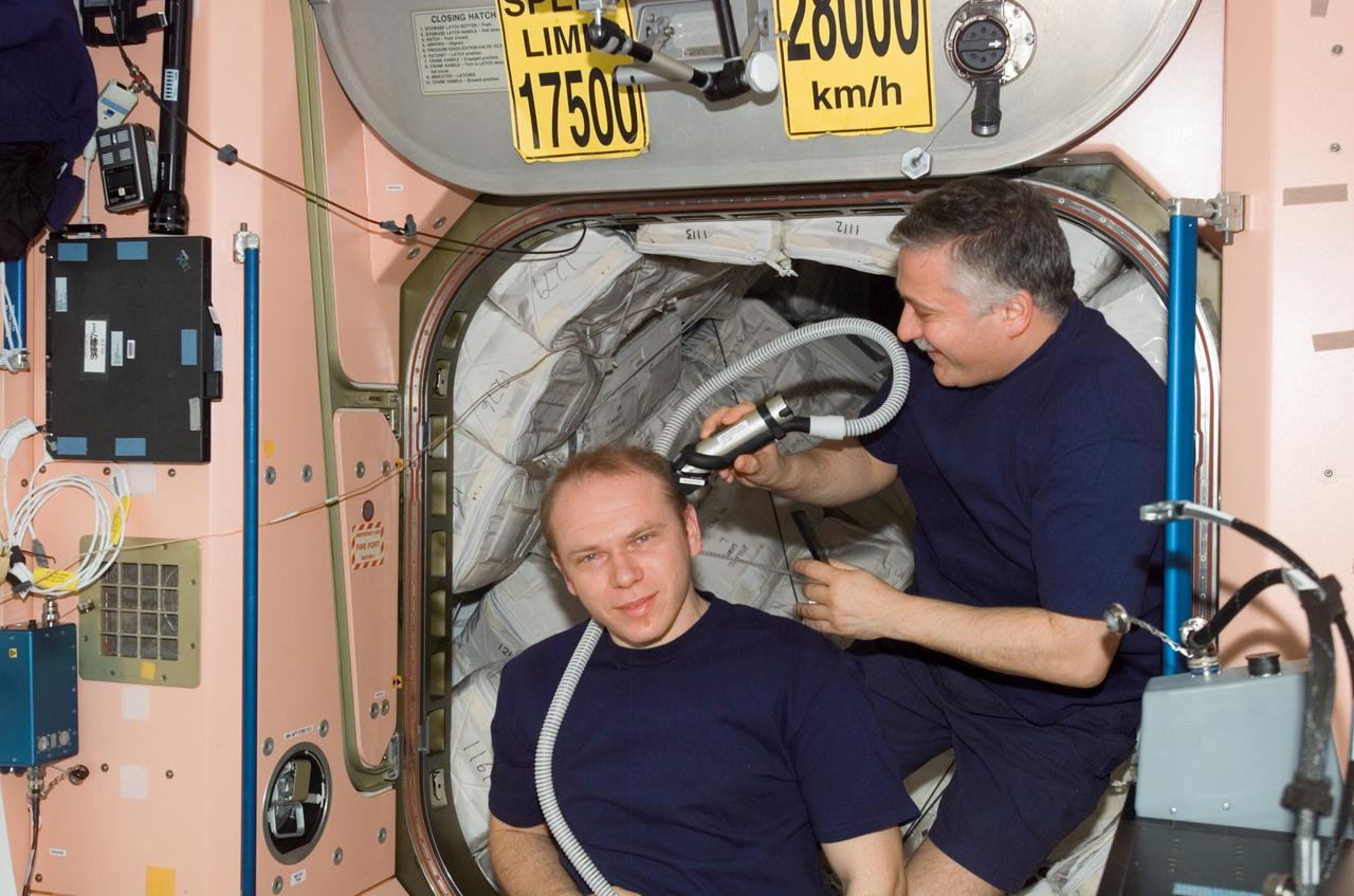 ISS015-E-07566 (13 May 2007) --- Cosmonaut Fyodor N. Yurchikhin, Expedition 15 commander, trims cosmonaut Oleg V. Kotov's hair in the Unity node of the International Space Station. Yurchikhin used hair clippers fashioned with a vacuum device to garner freshly cut hair. Kotov, flight engineer, and Yurchikhin represent Russia's Federal Space Agency.