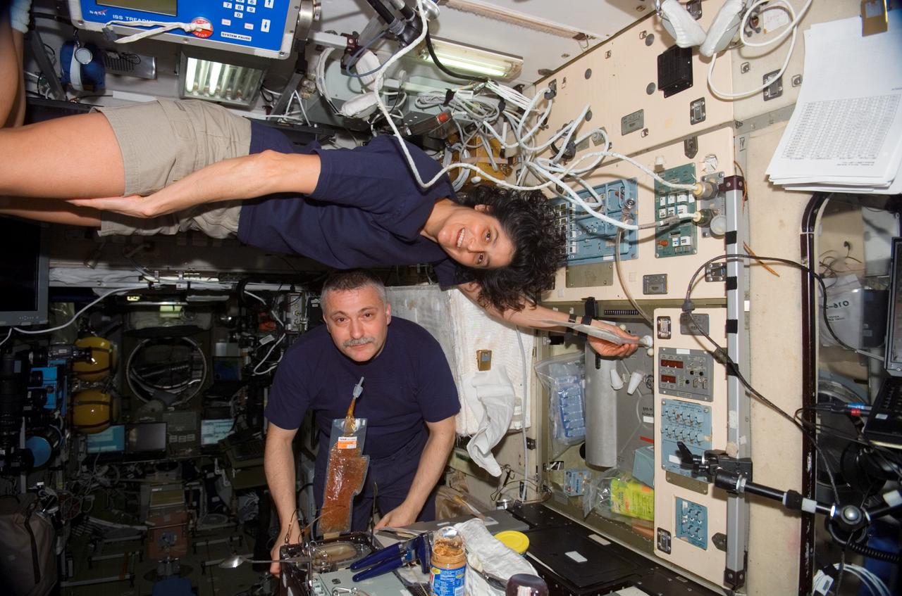 ISS015-E-09509 (25 May 2007) --- Astronaut Sunita L. Williams (top), Expedition 15 flight engineer, and cosmonaut Fyodor N. Yurchikhin, commander representing Russia's Federal Space Agency, share a meal at the galley in the Zvezda Service Module of the International Space Station.