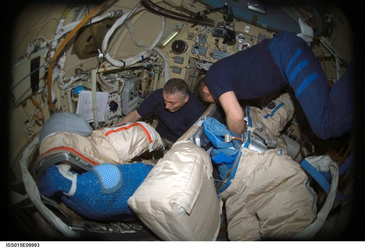 ISS015-E-09993 (30 May 2007) --- Cosmonauts Fyodor N. Yurchikhin (left) and Oleg V. Kotov, Expedition 15 commander and flight engineer, respectively, representing Russia's Federal Space Agency, work with Russian Orlan spacesuits in the Pirs Docking Compartment of the International Space Station.