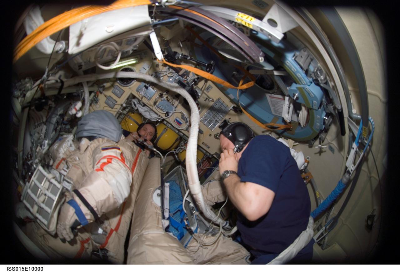 ISS015-E-10000 (30 May 2007) --- Cosmonauts Fyodor N. Yurchikhin (background) and Oleg V. Kotov, Expedition 15 commander and flight engineer, respectively, representing Russia's Federal Space Agency, work with Russian Orlan spacesuits in the Pirs Docking Compartment of the International Space Station.