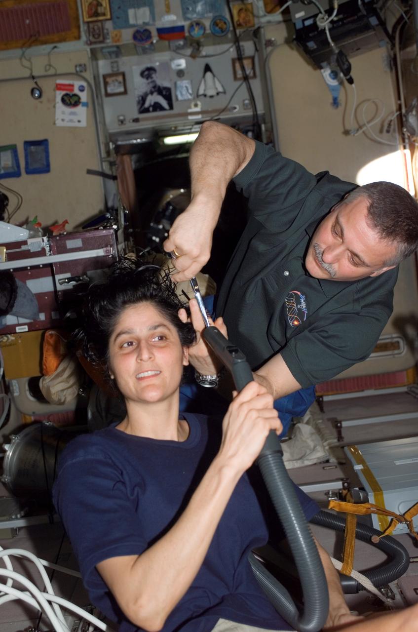 ISS015-E-10595 (3 June 2007) --- Cosmonaut Fyodor N. Yurchikhin, Expedition 15 commander representing Russia's Federal Space Agency, cuts astronaut Sunita L. Williams' hair in the Zvezda Service Module of the International Space Station. Williams, flight engineer, holds a vacuum device fashioned to garner freshly cut hair.