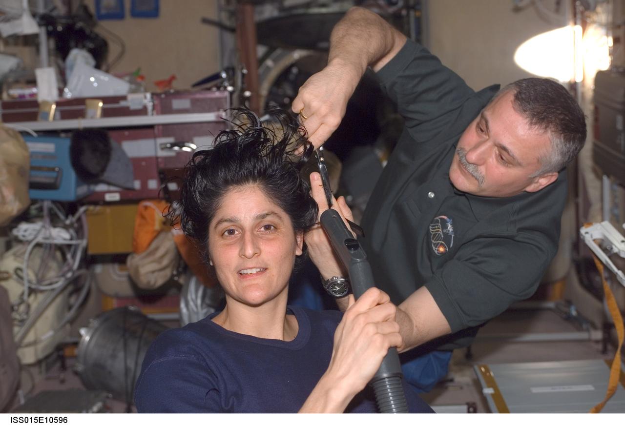 ISS015-E-10596 (3 June 2007) --- Cosmonaut Fyodor N. Yurchikhin, Expedition 15 commander representing Russia's Federal Space Agency, cuts astronaut Sunita L. Williams' hair in the Zvezda Service Module of the International Space Station. Williams, flight engineer, holds a vacuum device fashioned to garner freshly cut hair.