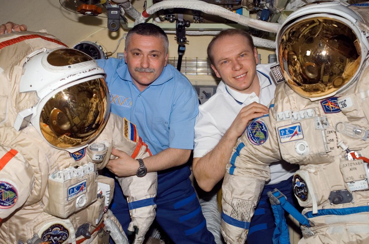 ISS015-E-10622 (3 June 2007) --- Cosmonauts Fyodor N. Yurchikhin (left) and Oleg V. Kotov, Expedition 15 commander and flight engineer, respectively, representing Russia's Federal Space Agency, pose for a photo with two Russian Orlan spacesuits in the Pirs Docking Compartment of the International Space Station.