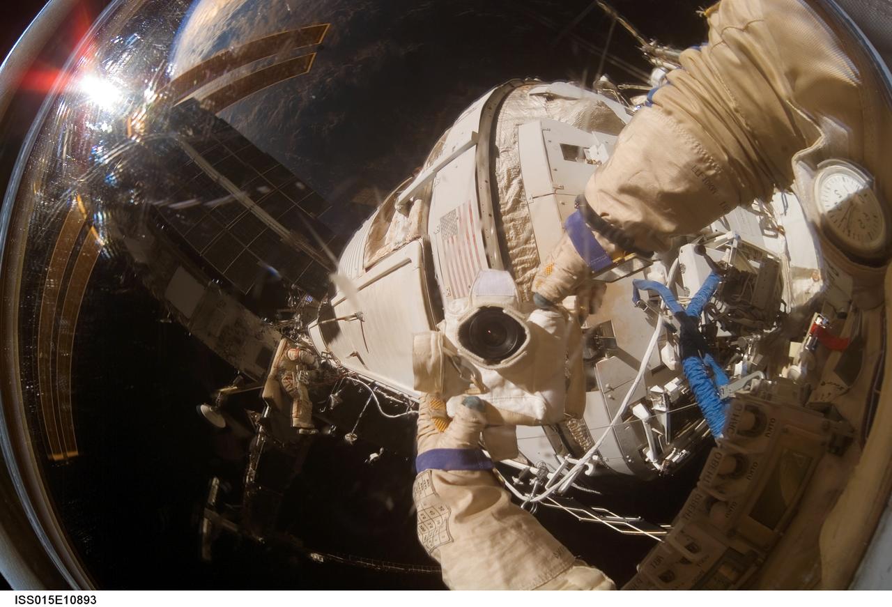 ISS015-E-10893 (6 June 2007) --- Cosmonaut Oleg V. Kotov, Expedition 15 flight engineer representing Russia's Federal Space Agency, wearing a Russian Orlan spacesuit, uses a digital still camera to expose a photo of his helmet visor during a session of extravehicular activity (EVA). A portion of the International Space Station is also visible in the reflections. Among other tasks, Kotov and cosmonaut Fyodor N. Yurchikhin (out of frame), commander representing Russia's Federal Space Agency, completed the installation of 12 more Zvezda Service Module debris panels and installed sample containers on the Pirs Docking Compartment for a Russian experiment, called Biorisk, which looks at the effect of space on microorganisms.