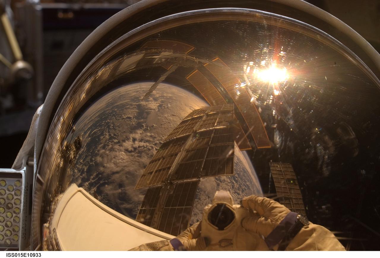 ISS015-E-10933 (6 June 2007) --- Cosmonaut Oleg V. Kotov, Expedition 15 flight engineer representing Russia's Federal Space Agency, wearing a Russian Orlan spacesuit, uses a digital still camera to expose a photo of his helmet visor during a session of extravehicular activity (EVA). With the Earth in the background, International Space Station solar array panels are also visible in the reflections. Among other tasks, Kotov and cosmonaut Fyodor N. Yurchikhin (out of frame), commander representing Russia's Federal Space Agency, completed the installation of 12 more Zvezda Service Module debris panels and installed sample containers on the Pirs Docking Compartment for a Russian experiment, called Biorisk, which looks at the effect of space on microorganisms.