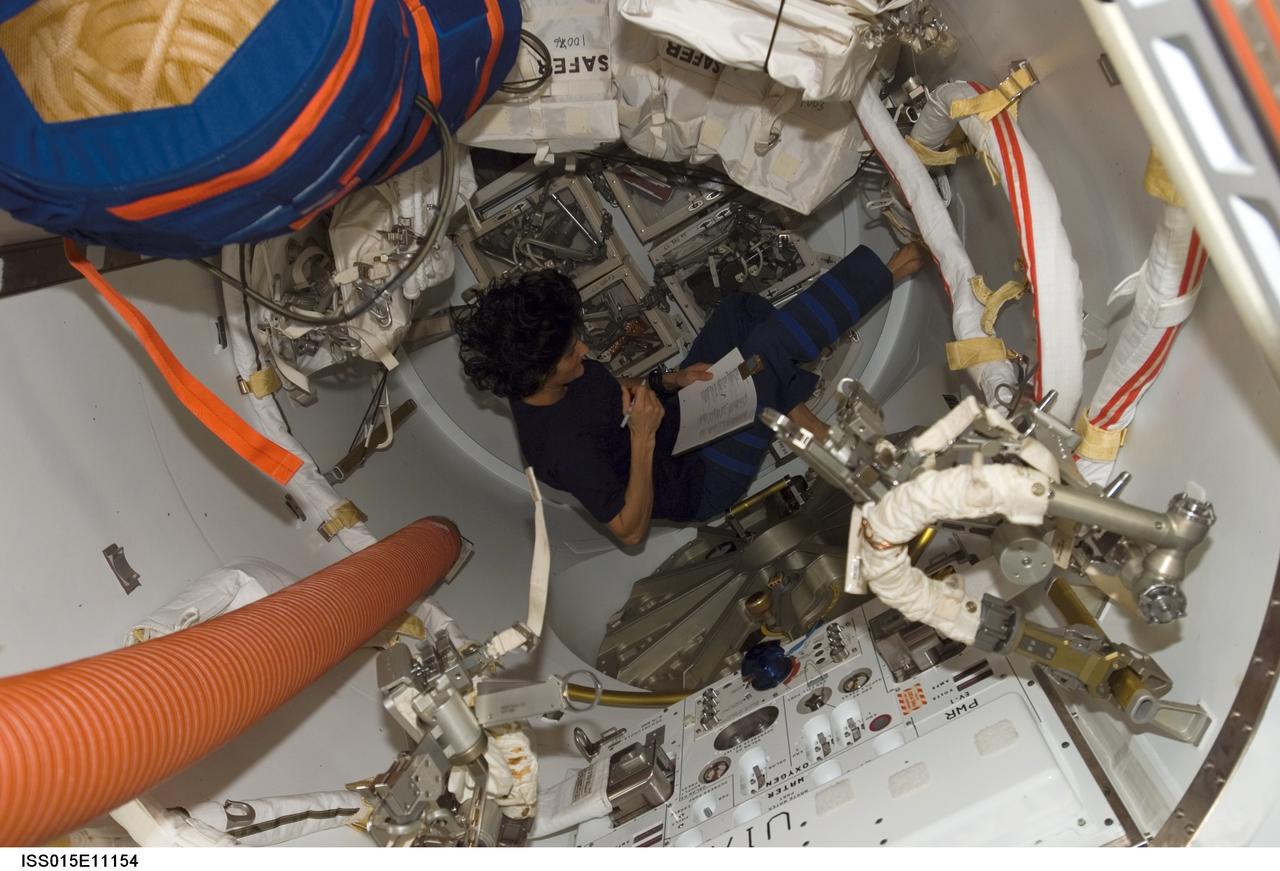 ISS015-E-11154 (7 June 2007) --- Astronaut Sunita L. Williams, Expedition 15 flight engineer, looks over procedures checklists in the Quest Airlock of the International Space Station.