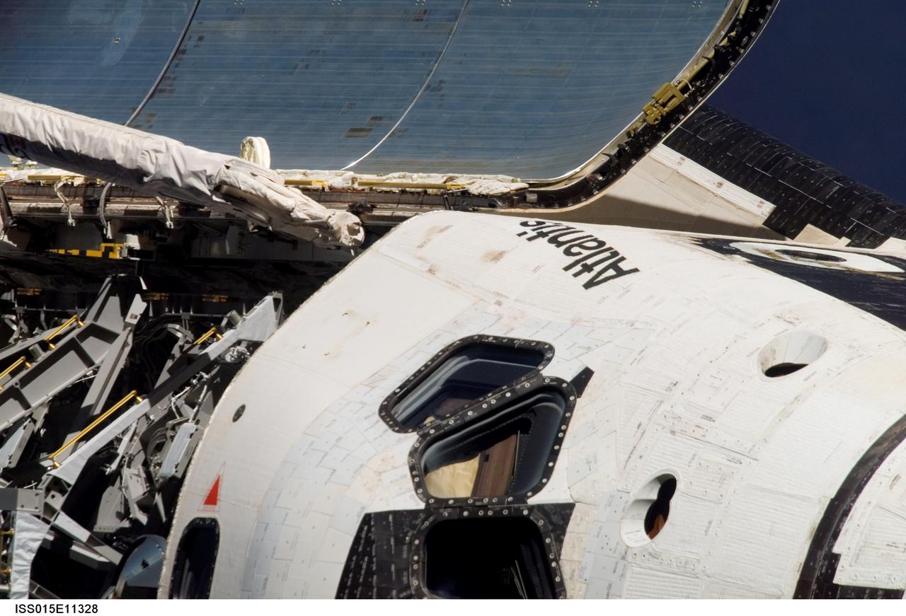 ISS015-E-11328 (10 June 2007) --- This is one of a series of images photographed with a digital still camera using an 800mm focal length featuring the different areas of the Space Shuttle Atlantis as it approached the International Space Station and performed a back-flip to accommodate close scrutiny by eyeballs and cameras.  This image shows part of  the commander's side or port side of Atlantis' cabin, including the hatch, as well as a section of the open payload bay cover and part of the docking system. Distance from the station and shuttle at this time was approximately 600 feet.