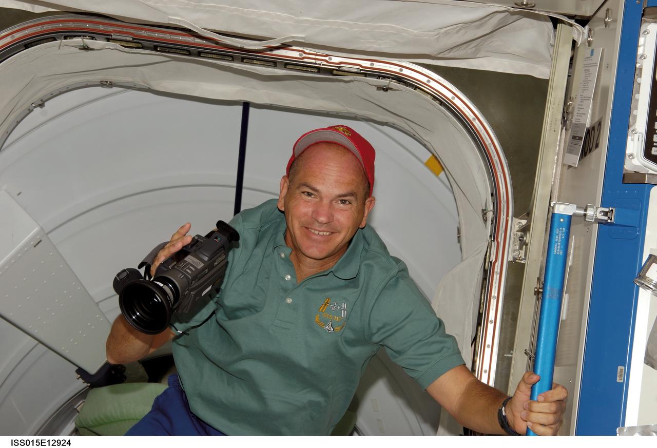 ISS015-E-12924 (12 June 2007) --- Astronaut Rick Sturckow, STS-117 commander, holds a camera near a hatch on the International Space Station during flight day five activities while Space Shuttle Atlantis was docked with the station.