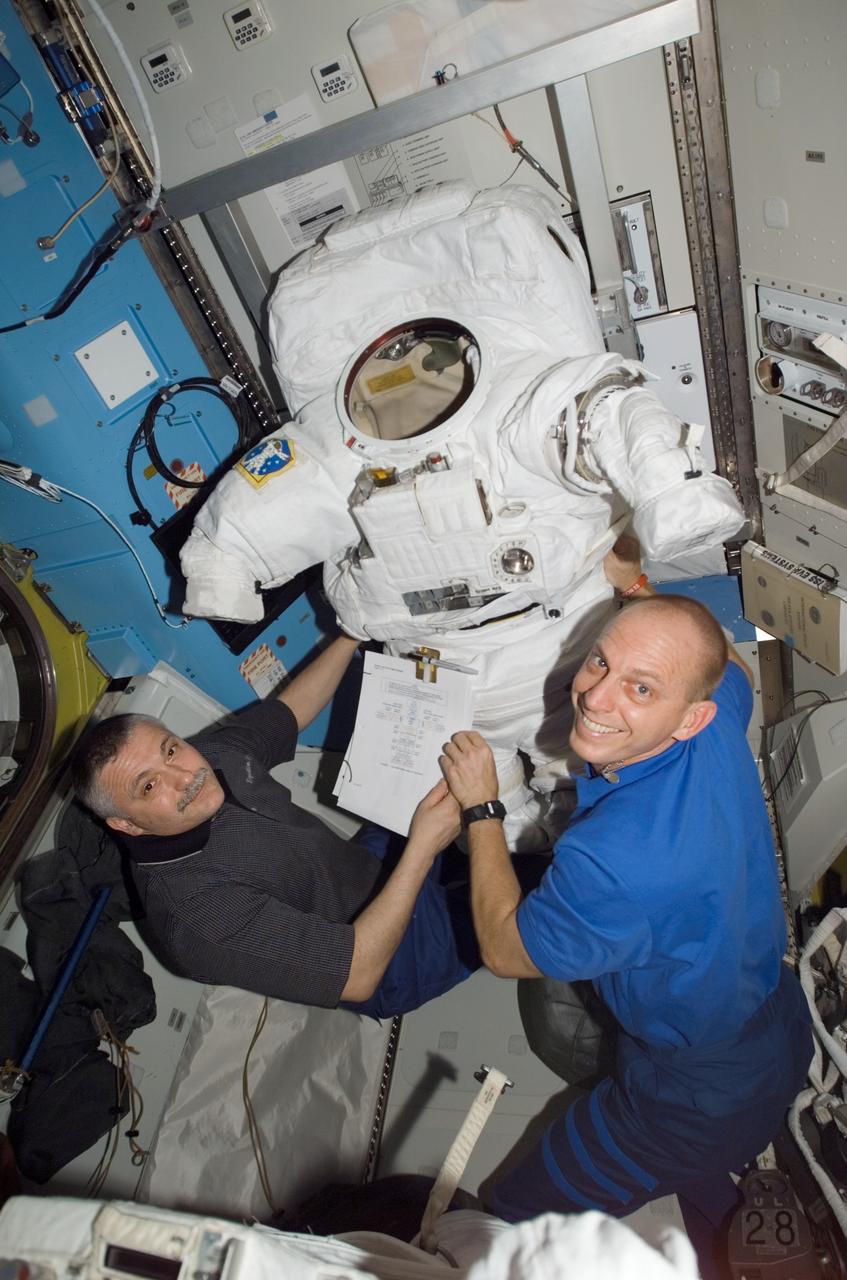 ISS015-E-15644 (2 July 2007) --- Cosmonaut Fyodor N. Yurchikhin (left), Expedition 15 commander representing Russia's Federal Space Agency, and astronaut Clayton C. Anderson, flight engineer, work with an Extravehicular Mobility Unit (EMU) spacesuit in the Quest Airlock of the International Space Station.