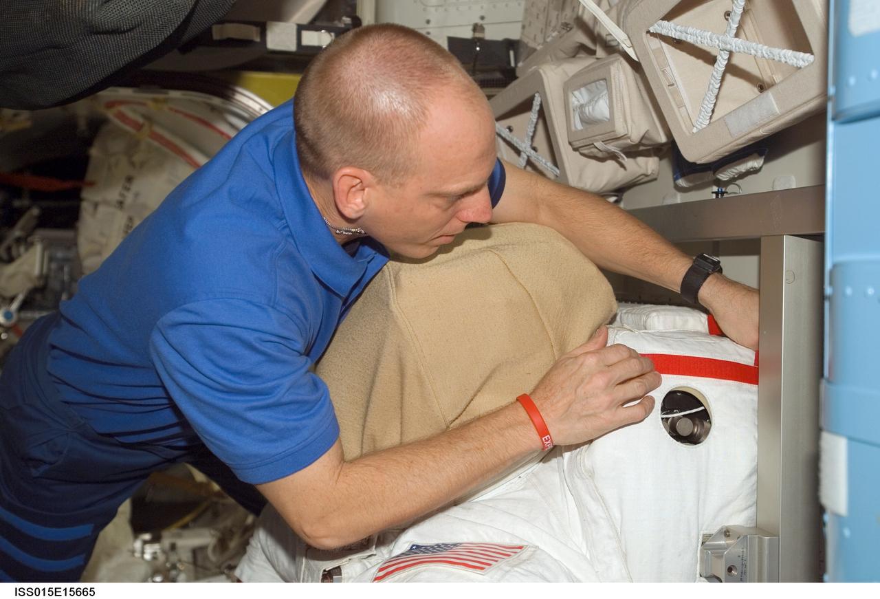 ISS015-E-15665 (2 July 2007) --- Astronaut Clayton C. Anderson, Expedition 15 flight engineer, works with an Extravehicular Mobility Unit (EMU) spacesuit in the Quest Airlock of the International Space Station.