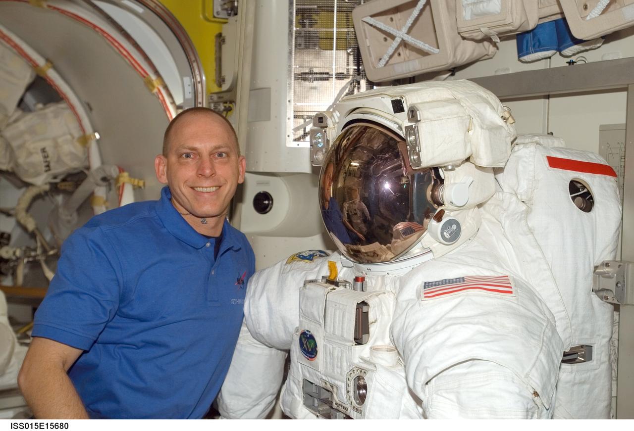 ISS015-E-15680 (2 July 2007) --- Astronaut Clayton C. Anderson, Expedition 15 flight engineer, poses for a photo with an Extravehicular Mobility Unit (EMU) spacesuit in the Quest Airlock of the International Space Station.