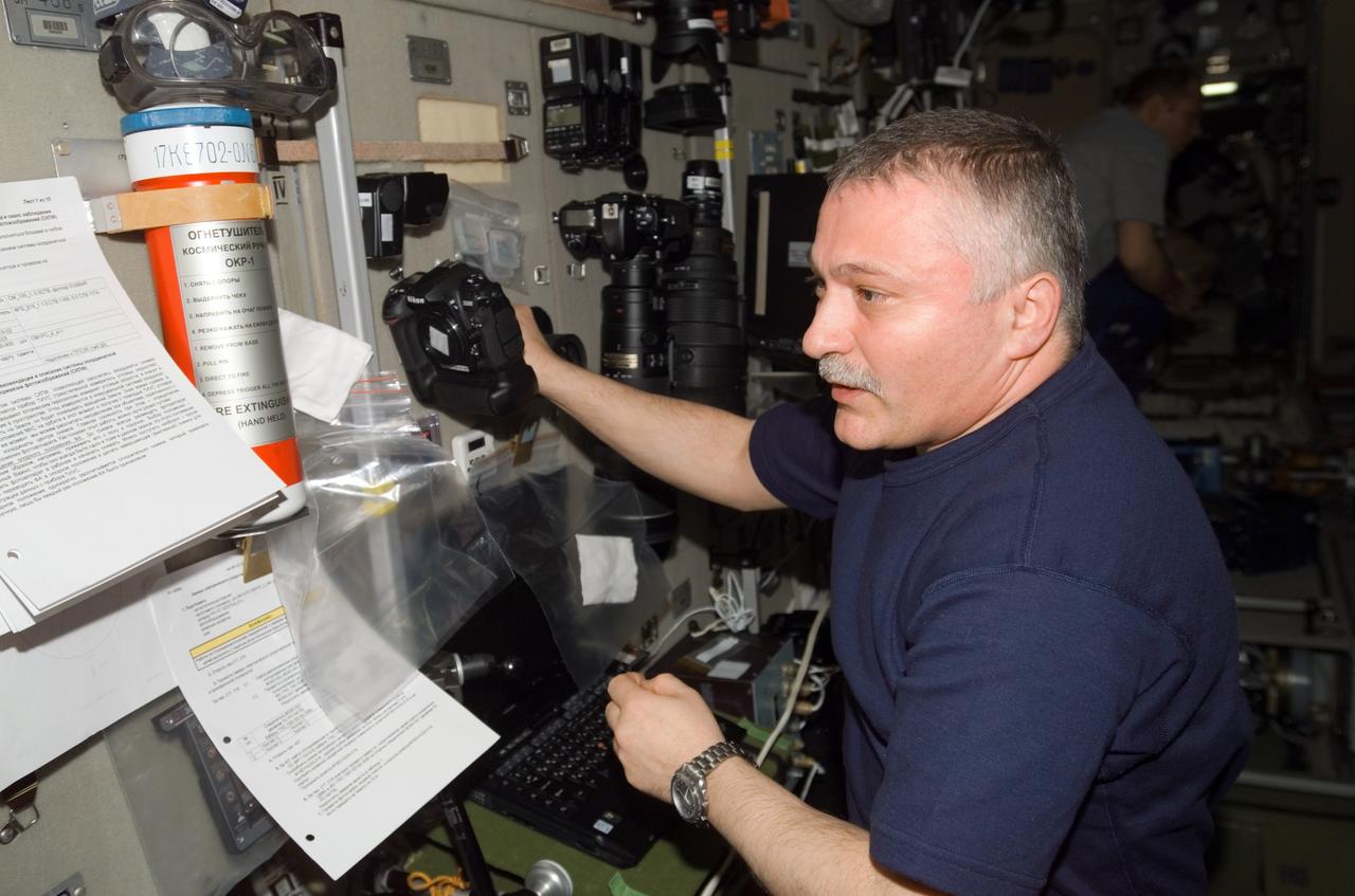 ISS015-E-17702 (6 July 2007) --- Cosmonaut Fyodor N. Yurchikhin, Expedition 15 commander representing Russia's Federal Space Agency, holds a camera while looking over procedures checklists in the Zvezda Service Module of the International Space Station.