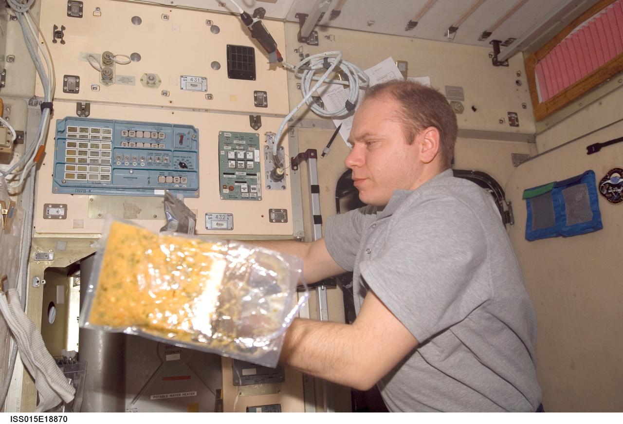 ISS015-E-18870 (21 July 2007) --- Cosmonaut Oleg V. Kotov, Expedition 15 flight engineer representing Russia's Federal Space Agency, prepares to eat a meal at the galley in the Zvezda Service Module of the International Space Station. A bag of food floats freely in the foreground near Kotov.